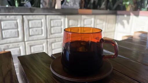 Amber glass mug of black coffee on a wooden table at PublicUs, Las Vegas